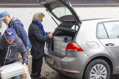 Margrit, freiwillige Fahrerin, steht vor ihrem Auto und prüft, welche Kunden sie heute anfährt.